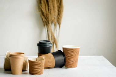 Tek kullanımlık bir sürü kağıt bardak. Kahve ya da gri arka planda çay için el işi kağıt bardaklar. Sıfır atık, plastiksiz konsept. 