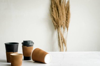 Tek kullanımlık bir sürü kağıt bardak. Kahve ya da gri arka planda çay için el işi kağıt bardaklar. Sıfır atık, plastiksiz konsept. 