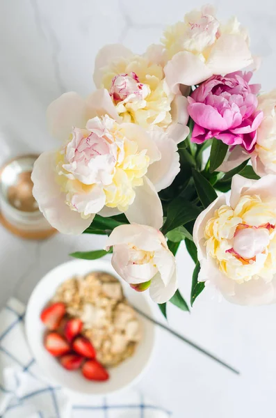 Kahvaltı masası. Güneşli bir günde ev yapımı granola, taze çilek ve çiçeklerle servis edilir.. 