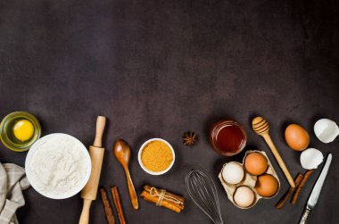Top view of ingredients bakery making on dark old table. Flour, eggs,  sugar and  cinnamon. Ingredients for making dough, cakes, muffins, pies. 