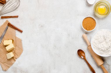 Baking homemade cookies on gray kitchen worktop with ingredients -flour, eggs,  sugar and  cinnamon. culinary background, copy space, overhead view