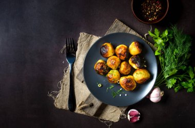 Karanlık masadaki eski tavada akşam yemeği için taze haşlanmış patates, tuz ve yağ. konsept sade yemek