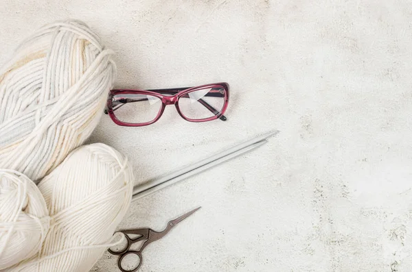 Light Beige Knitting Wool Knitting Needles Eyeglesses Conkrete Background Female — Stock Photo, Image