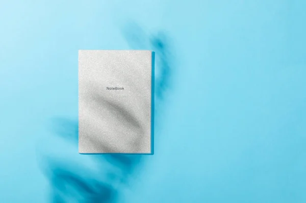 Blanco Notebook Mockup Met Schaduw Van Bladeren Blauwe Achtergrond Elegante — Stockfoto