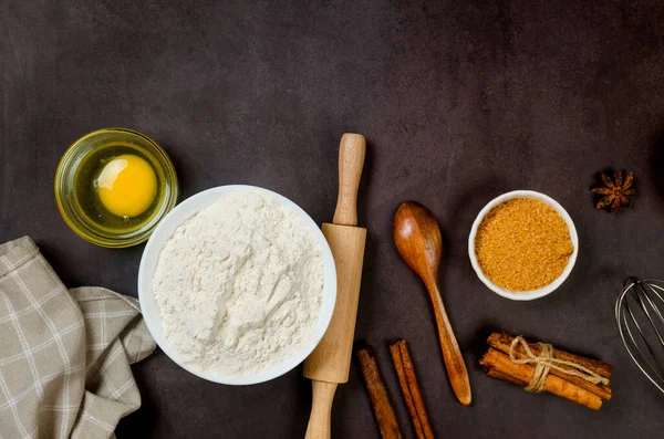 Top view of ingredients bakery making on dark old table. Flour, eggs,  sugar and  cinnamon. Ingredients for making dough, cakes, muffins, pies. 