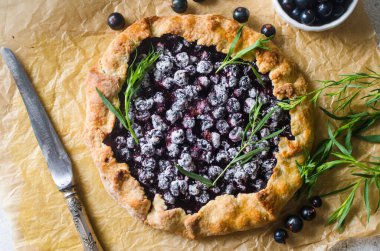 Homemade blackcurrant galette on old concrete background. Open pie. Top view of homemade pie crust on the table. rustic home baked fruit pie.