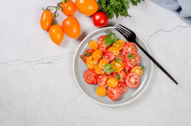 Healthy salad with red and yellow cherry tomato, sesame and parsley in plate. Summer food concept. Selective focus