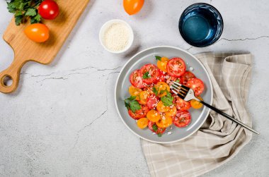 Healthy salad with red and yellow cherry tomato, sesame and parsley in plate. Summer food concept. Selective focus