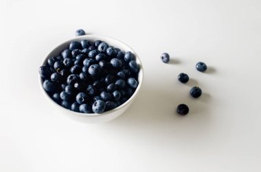 Ripe, sweet blueberries in white ceramic bowl on table for healthy nutrition. Concept for healthy eating and nutrition