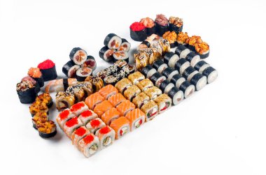 Big set with different kind of rolls and sushi  over white background. Japanese food restaurant delivery. maki, salmon, philadelphia and california rolls big party set