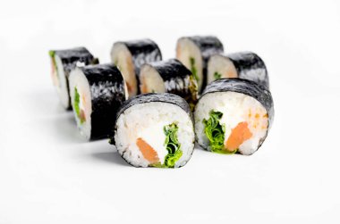 Sushi rolls with salmon, cream cheese  and lettuce on white background. Traditional Japanese cuisine. 