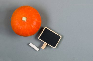 Kopya alanı olan boş bir karatahta ile balkabağı. Sonbahar konsepti, mevsimlik alışveriş, indirim. İçeriğinizi eklemek için şablon oluşturun. 