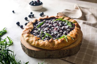 Homemade blackcurrant galette on old concrete background. Open pie. Top view of homemade pie crust on the table. rustic home baked fruit pie.