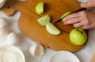 Ev yapımı elma ve erik galeti yapma süreci. Mevsimlik geleneksel sonbahar pişirme. Kadın tahtada elma kesiyor. Pişirme kavramı. 