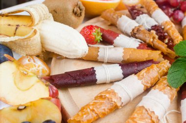 Gri arka planda çeşitli kurutulmuş cips ve olgun meyveler. Meyve cipsi. Sağlıklı beslenme konsepti, atıştırmalık, şekersiz. Üst görünüm, alanı kopyala. 