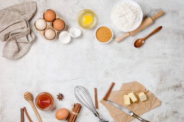 Gri mutfak atölyesinde içinde un, yumurta, şeker ve tarçın bulunan ev yapımı kurabiyeler pişirmek. Mutfak arka planı, kopyalama alanı, genel görünüm