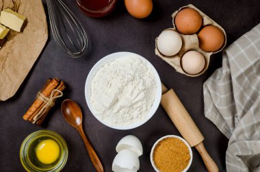 Malzeme fırınının koyu eski masa üzerindeki en iyi görüntüsü. Un, yumurta, şeker ve tarçın. Hamur, kek, kek ve turta yapmak için gerekli malzemeler.. 