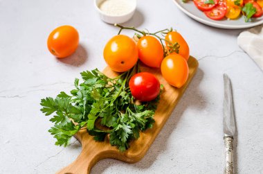Yellow and red tomatoes on cutting board. ingredients for cooking fresh healthy vegetable salad. Summer food concept. Selective focu