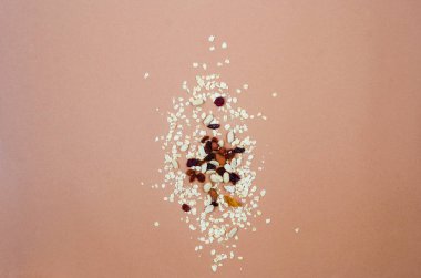 Fındıklı yulaf ezmesi ve bej arka planda kurutulmuş meyve. Sağlıklı atıştırmalık ya da kahvaltı konsepti - tahıllı granola, fındık, kuru meyve.