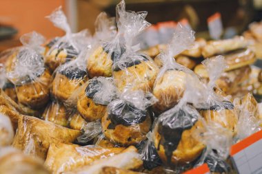 Bir sürü romlu baba keki ve süpermarket tezgahında polietilen ambalajlı çikolata. Tatlı tatlılar, lezzetli yemekler.