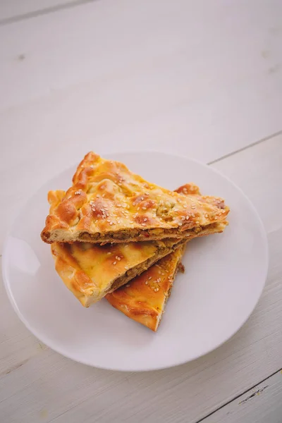 Tahta arka planda beyaz tabakta biraz et ve havuçlu turta. Lezzetli sağlıklı yiyecekler. Diyet, beslenme, yeme alışkanlıkları. Mesaj için yer. Dikey çekim.