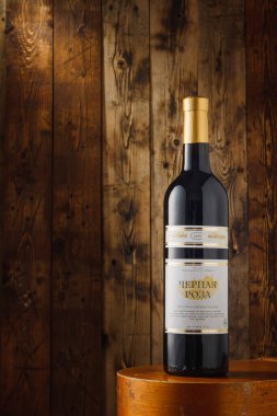 İzmail, Ukrayna. 8 Mayıs 2022. Ukrayna üzümünden bir şişe kırmızı şarap. Kahverengi ahşap arka planda siyah Odesa şarabı.
