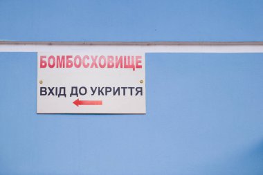 Üzerinde Ukrayna 'nın bombalı sığınağı yazan tabela. Sığınak girişi. Hava saldırısı uyarısı. Acil durum işareti. Rusya-Ukrayna Savaşı 2022.