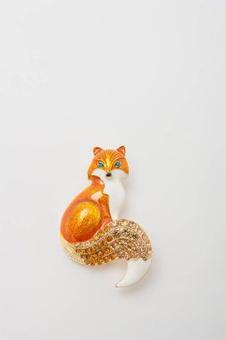 Metallic brooch in shape of fox with orange gemstone imitation, pin isolated on white background, bijouterie, jewelry close up