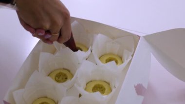 Pasta poşetinden taze keklerin üzerine reçel sıkan bir kadın. Tatlı yapmak, ev yapımı hafif tatlı. Yakın çekim, sadece el görünür.