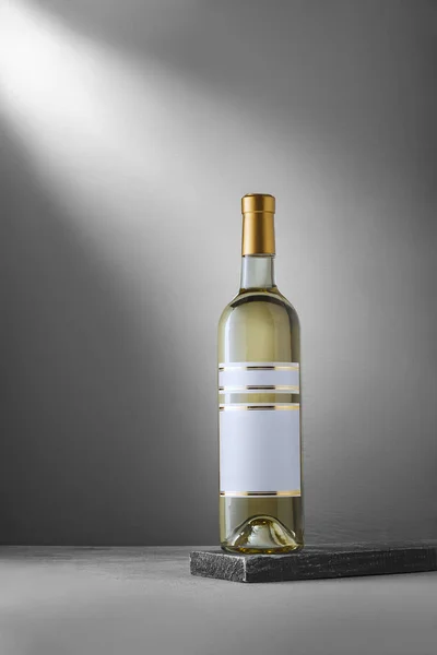 Alman Riesling üzümlü beyaz şarap şişesi. Ahşap arka planda boş etiketli, marka şablonu yok, maketi yok. Dikey çekim