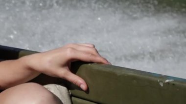 Nehirde ya da gölde yüzen bir kadın yelkenli. Arka planda su sıçraması, yakın çekim.