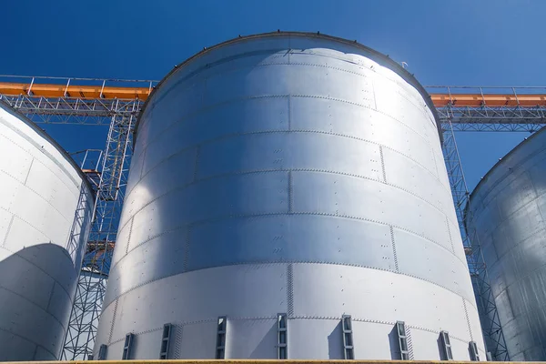 Granary elevator, Ukrainian grain storage on blue sky background. International wheat, seed and corn supplier. War 2022 in Ukraine. Agriculture