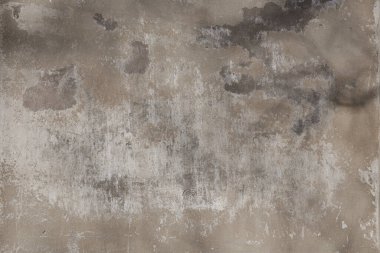 Eski boya ve çimento katmanlarıyla sıvanmış tuğladan bir duvar parçası.