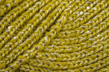 Ürün, tellerdeki çeşitli döngülerle birbirine bağlı yünlü ipliklerden yapılmıştır.