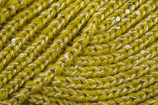 Ürün, tellerdeki çeşitli döngülerle birbirine bağlı yünlü ipliklerden yapılmıştır.