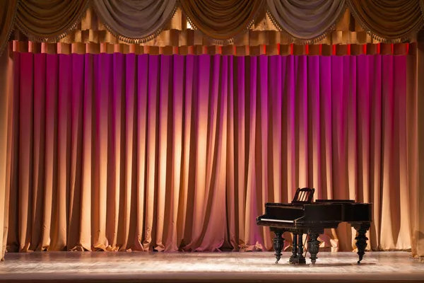バックステージと装飾柱の照明で照らされた古いグランドピアノがあります — ストック写真