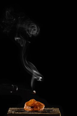 Yanan fitil ve dumanlı mum, siyah arka planda izole edilmiş.
