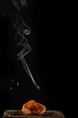 Yanan fitil ve dumanlı mum, siyah arka planda izole edilmiş.