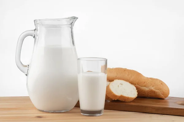 Eine Glaskanne Mit Milch Und Ein Glasständer Auf Einem Holztisch — Stockfoto
