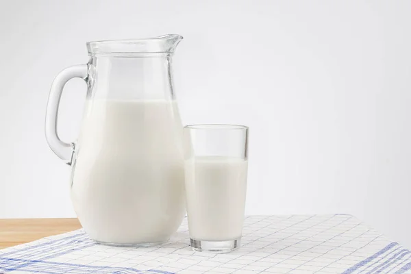 Eine Glaskanne Mit Milch Und Ein Glasständer Auf Einem Holztisch — Stockfoto