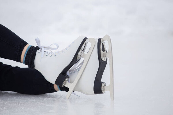 Девушка в черных брюках катается на коньках по льду стадиона в течение дня