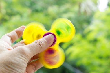 Fidget Döndürücü (El Döndürücü) hızla doğa arka planı üzerinde dönüyor