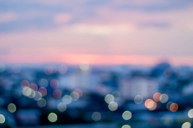 Gece aydınlığı şehrinin soyut bulanıklığı dağ ve günbatımı gökyüzü arkaplanı