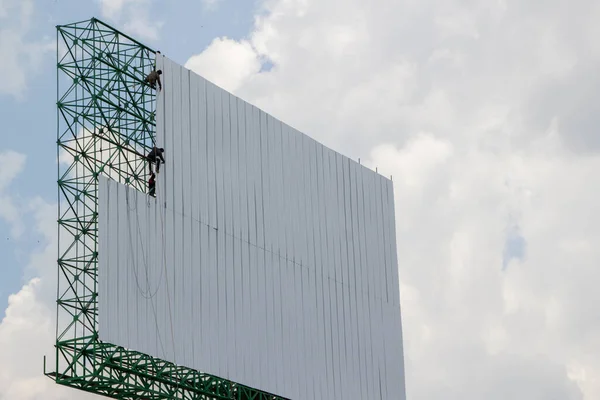 Arbetare Installera Metallplåtar Stor Affisch Med Bakgrund Blå Himmel Och — Stockfoto