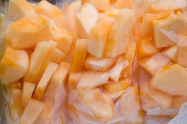 Tayland sokak pazarında plastik torbalarda taze kavun dilimleri..