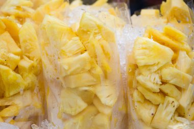 Tayland sokak pazarında plastik torbalarda taze ananas dilimleri.