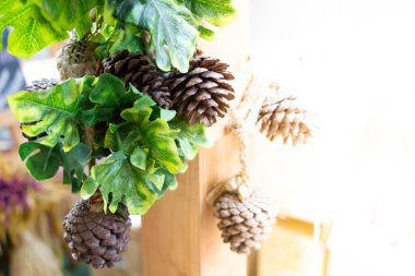 Evi dekore etmek için yeşil yapraklı yapay kozalaklar.