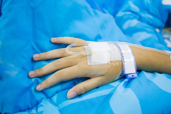 在医院床上躺着一个有盐水的病女 — 图库照片