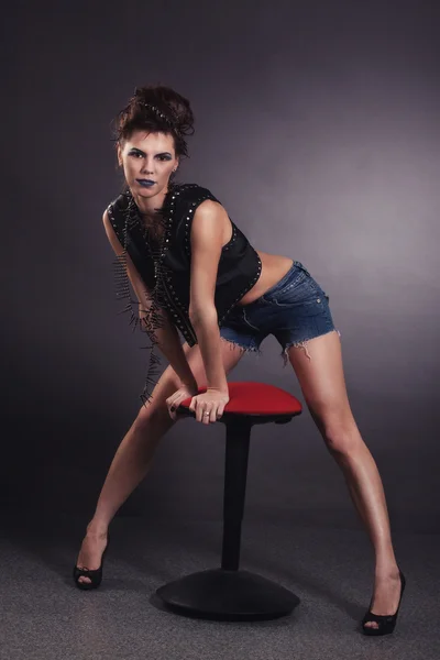 Сексуальная женщина-рокер со стулом — стоковое фото
