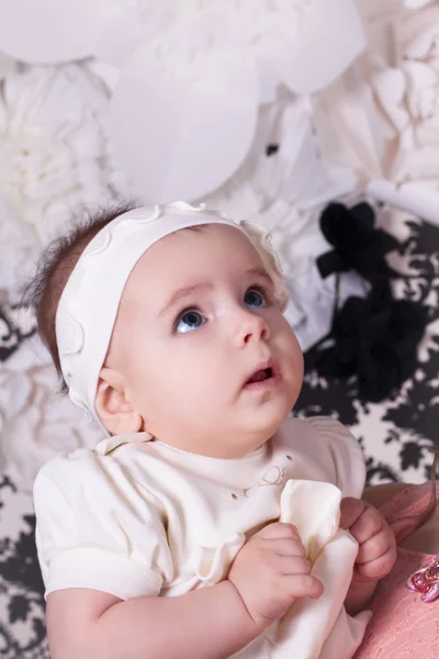 Menina 6 meses vestido branco olha para cima em surpresa — Fotografia de Stock